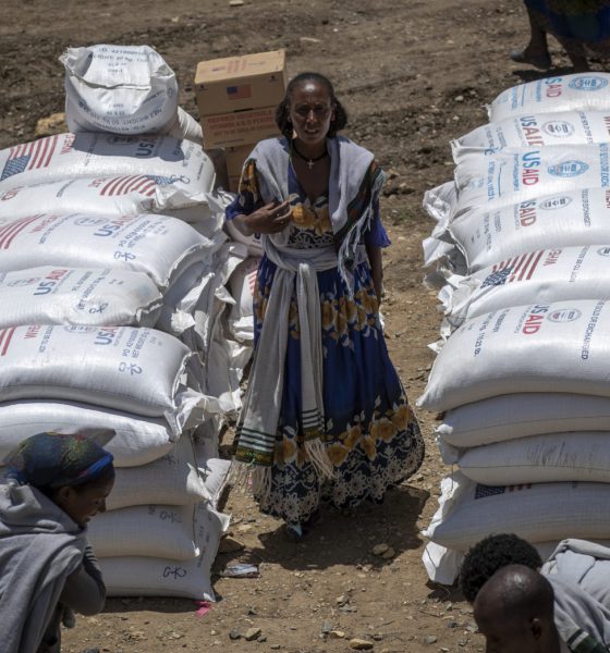 An Ethiopian woman stands by sacks of wheat to be distributed by the Relief Society of Tigray in the town of Agula, in the Tigray region of northern Ethiopia Saturday, May 8, 2021. (AP Photo/Ben Curtis, File)